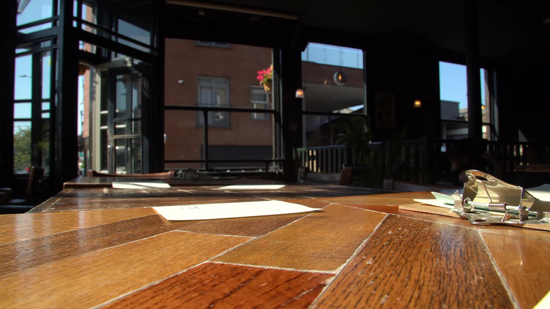 Pint of Beer Resting on Indoor London Pub Table with Sunlit Exterior