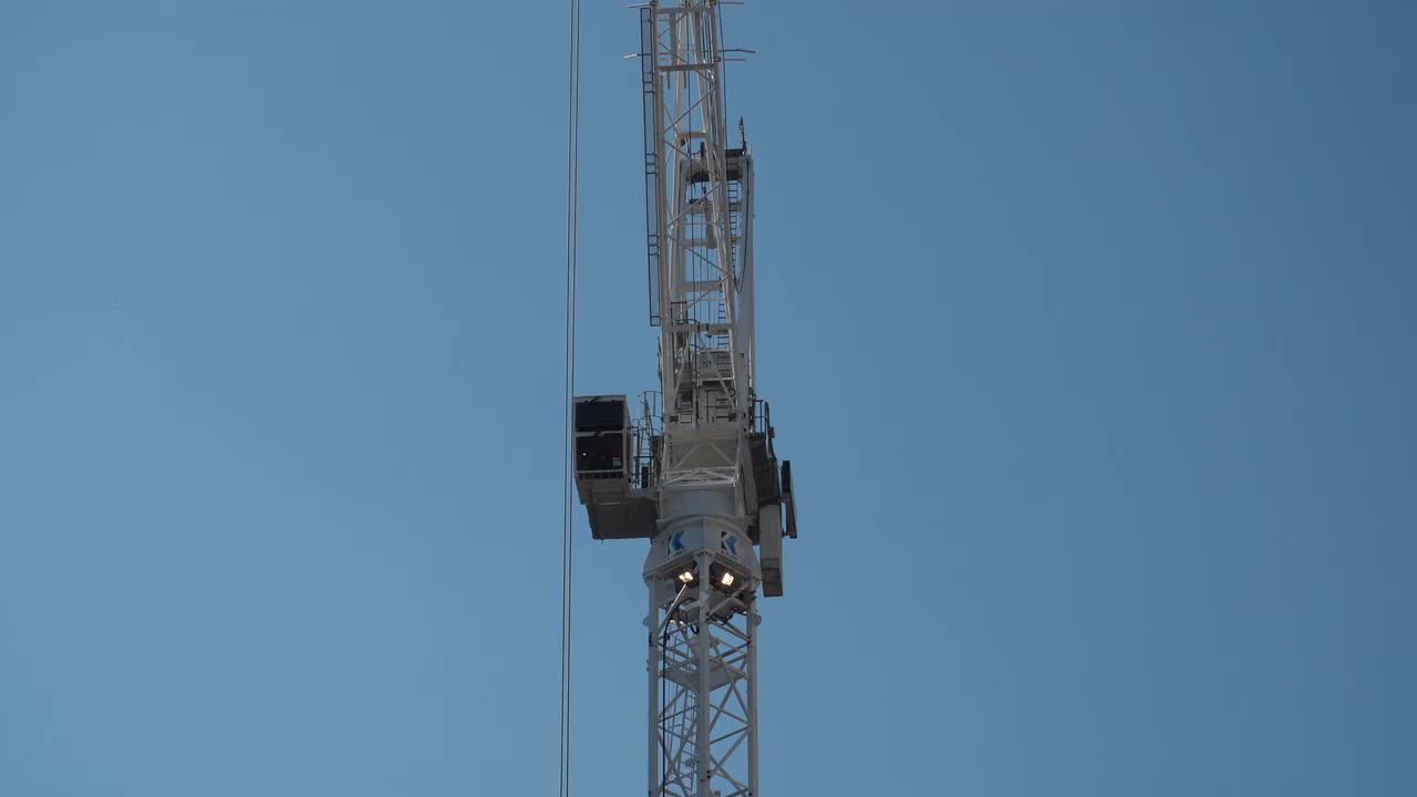 Tower Crane on Construction Site Against Blue Sky