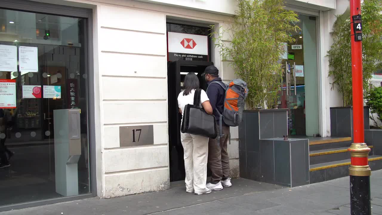 People Using HSBC ATM in Urban Setting