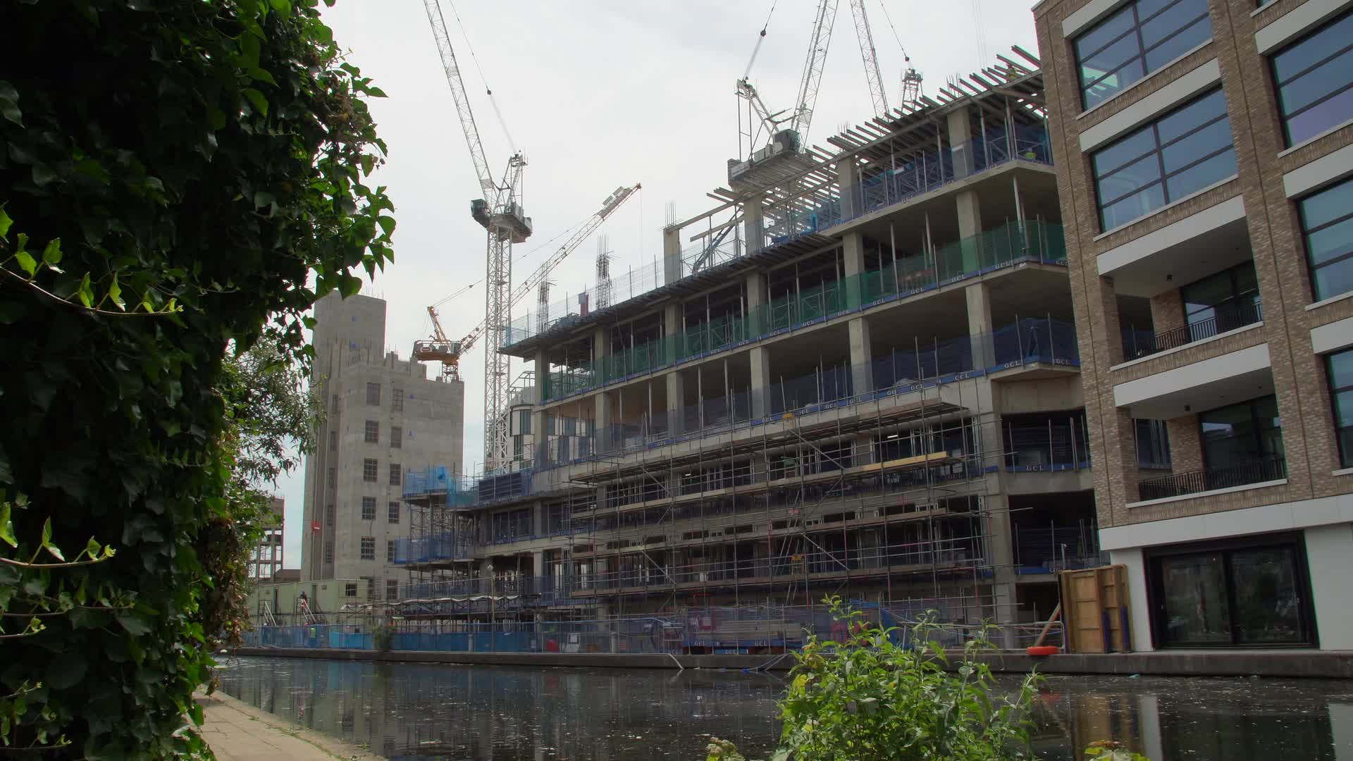 Urban Canal-Side Construction Site with Cranes and Scaffolding in London