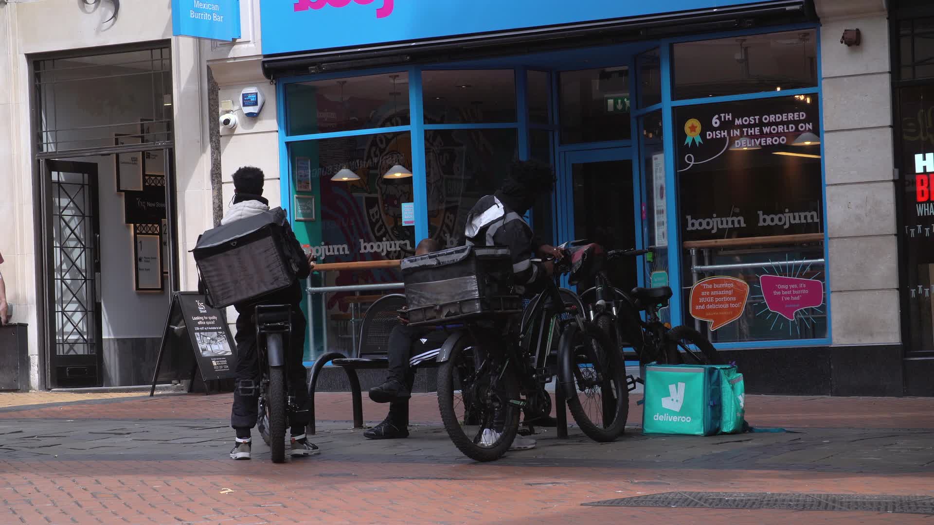 Deliveroo Couriers Waiting Outside Restaurant in Birmingham City Centre