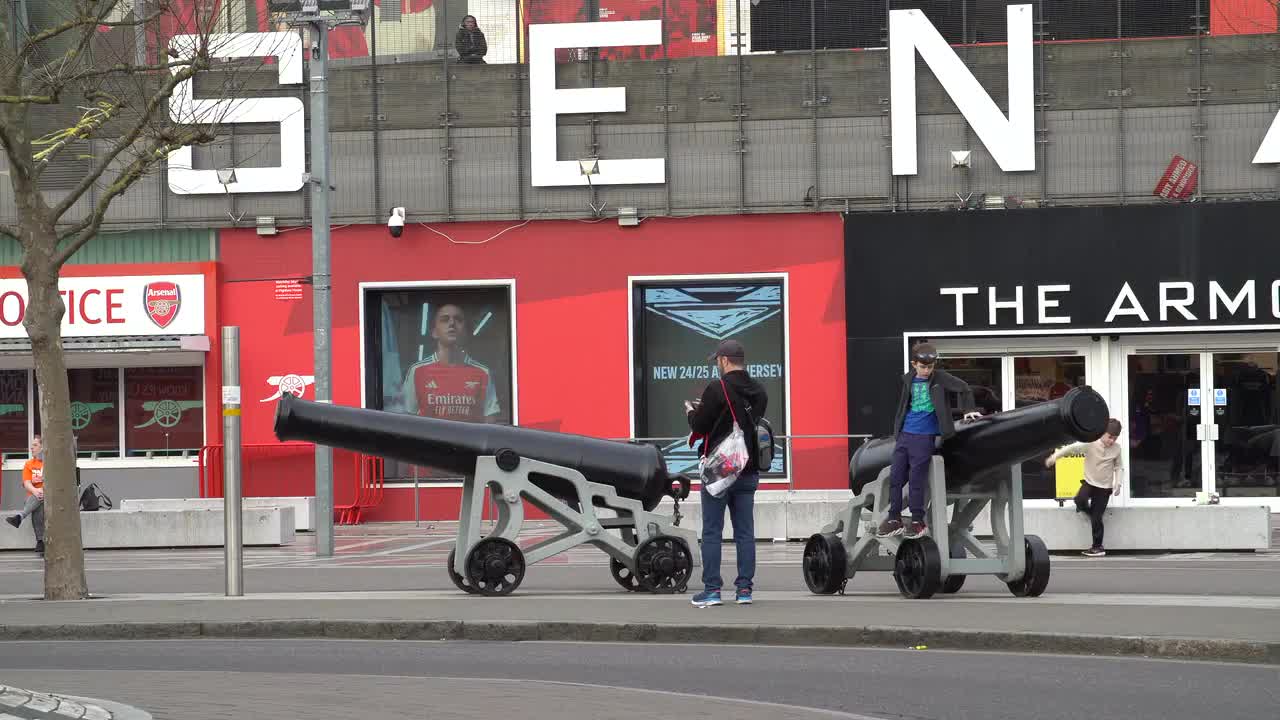 Arsenal Stadium Exterior with Cannons and Visitors