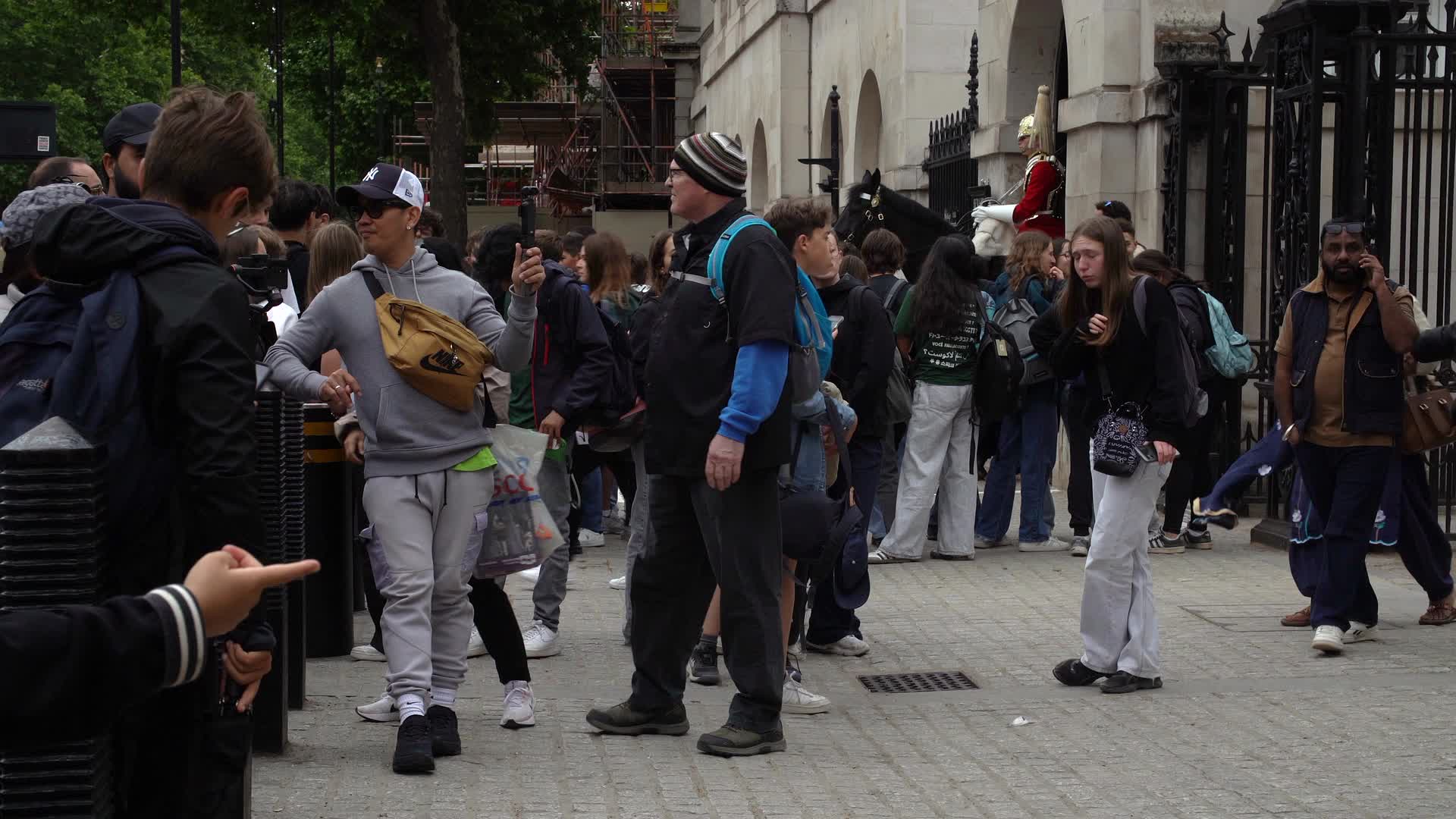 Busy Tourist Gathering beside King's Guard in London with British Flag Visible