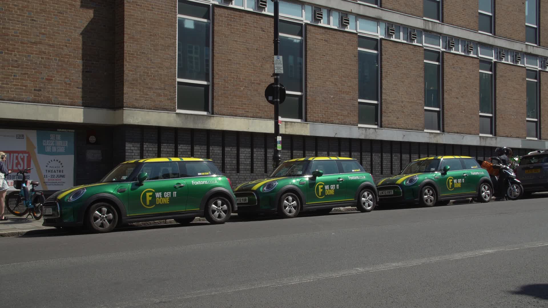 Foxtons Branded Mini Coopers Parked in Sunny Urban Street in London
