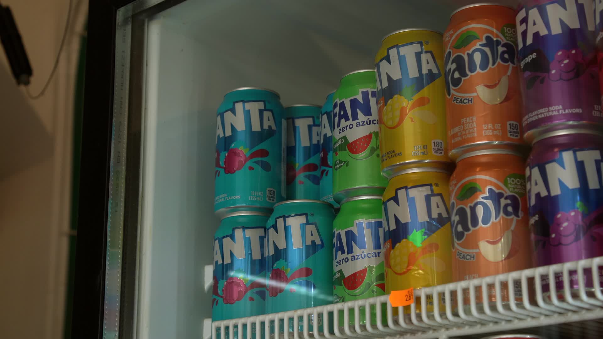 Colorful Variety of Fanta Cans in Refrigerator Display