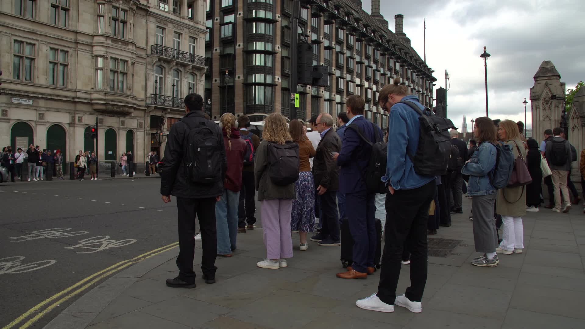 Crowd of People Waiting at London Intersection in Overcast Weather