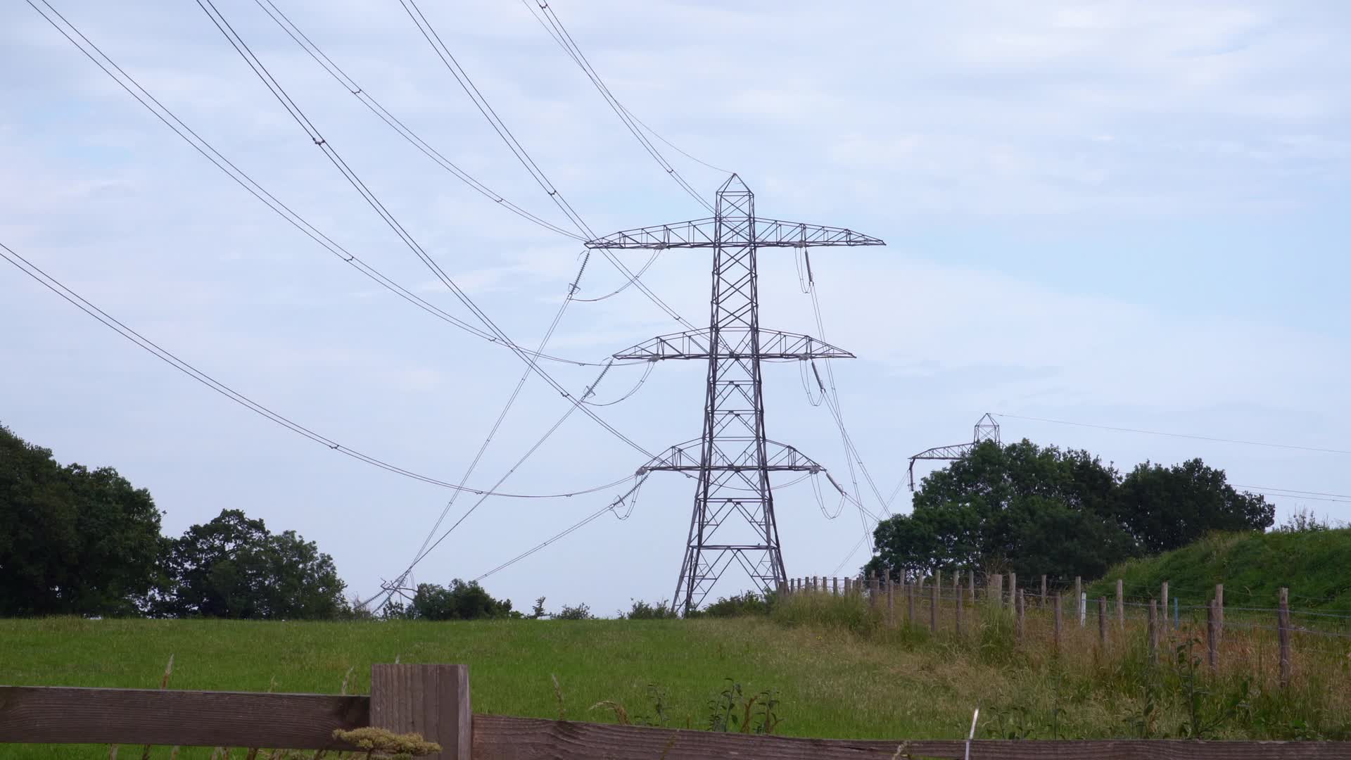 High Voltage Pylons in Countryside Landscape