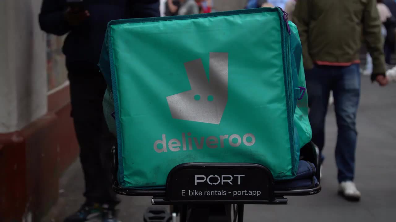 Deliveroo Delivery Cyclist on Busy Urban Street