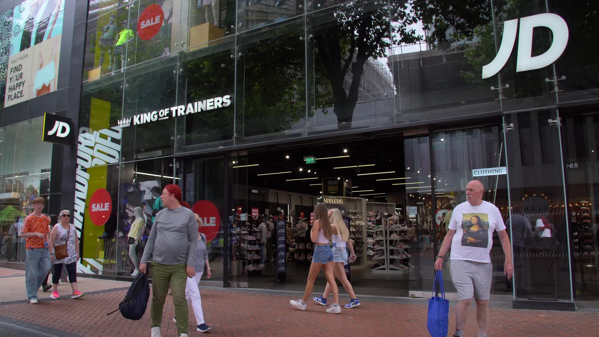 Shoppers Pass by JD Sports Storefront in Birmingham, UK